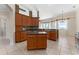 Open kitchen with island, wood cabinets, dark countertops, and lots of natural light at 11720 Indian Hills Ln, Clermont, FL 34711