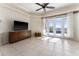 Bright living room with tile flooring, ceiling fan, and sliding glass doors at 11720 Indian Hills Ln, Clermont, FL 34711