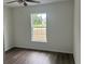 Bedroom with ceiling fan, wood floors, and window view at 13075 Se 35Th Ct, Belleview, FL 34420