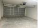 Bright and spacious garage area with a gray automatic garage door system at 13075 Se 35Th Ct, Belleview, FL 34420