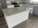 Kitchen island features granite countertops and modern white cabinets at 13075 Se 35Th Ct, Belleview, FL 34420