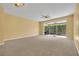 Spacious carpeted living room with ceiling fan and sliding glass doors leading to a screened lanai at 1541 Florentino Ln, Winter Park, FL 32792