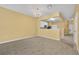 Carpeted living room features a chandelier, half wall divider, and a clear view of the kitchen area at 1541 Florentino Ln, Winter Park, FL 32792