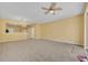 Open-concept living room with carpet, ceiling fan, chandelier and seamless flow to the kitchen area at 1541 Florentino Ln, Winter Park, FL 32792