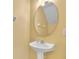 A half bath features a pedestal sink, oval mirror, and light fixture at 1541 Florentino Ln, Winter Park, FL 32792
