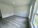 Empty bedroom featuring light grey wood floors, white walls, and a window providing natural light at 16697 Sw 23Rd Avenue Rd, Ocala, FL 34473