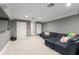 A finished basement has a plush navy sofa and neutral carpet at 17726 Dangler Rd, Winter Garden, FL 34787