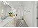 A bright bathroom featuring a double vanity, large mirror, and ample storage space at 17726 Dangler Rd, Winter Garden, FL 34787