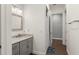 A bathroom view with gray cabinets, marble countertop and a view to the hallway at 17726 Dangler Rd, Winter Garden, FL 34787