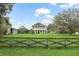 Charming two-story home featuring a manicured lawn, fenced yard, and inviting front porch, perfect for Gathering living at 17726 Dangler Rd, Winter Garden, FL 34787