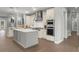 A modern kitchen featuring white cabinets, stainless steel appliances, and a gray center island with white countertop at 17726 Dangler Rd, Winter Garden, FL 34787