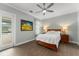 Comfortable main bedroom features stylish decor, a ceiling fan and access to screened lanai at 17726 Dangler Rd, Winter Garden, FL 34787