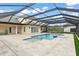 Expansive travertine deck surrounds the screened pool and spa at 17726 Dangler Rd, Winter Garden, FL 34787