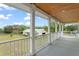 A covered porch with white columns overlooks the fenced pasture and barn on the property at 17726 Dangler Rd, Winter Garden, FL 34787