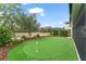 Manicured putting green in backyard with lush landscaping at 17726 Dangler Rd, Winter Garden, FL 34787