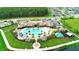 Gorgeous aerial view of community clubhouse and pool with palm trees, playground, walking paths, and green space at 2260 Rapollo Dr, Kissimmee, FL 34741