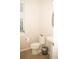 A well-lit half-bathroom features a toilet, sink, mirror, and a window offering natural light at 2260 Rapollo Dr, Kissimmee, FL 34741