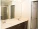 Modern bathroom with dual sinks, sleek cabinetry, and a tiled walk-in shower at 2260 Rapollo Dr, Kissimmee, FL 34741