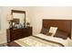 Comfortable bedroom featuring a wooden dresser with a mirror, decorative lamps, and a plush patterned bedspread at 2260 Rapollo Dr, Kissimmee, FL 34741