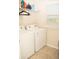 Functional laundry room equipped with a washer, dryer, and shelving for storage and a window at 2260 Rapollo Dr, Kissimmee, FL 34741
