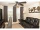 Home theater room featuring a ceiling fan, large window, leather sofa, and entertainment stand at 2260 Rapollo Dr, Kissimmee, FL 34741