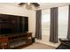 Living room featuring large window, ceiling fan, entertainment center, and a black leather couch at 2260 Rapollo Dr, Kissimmee, FL 34741