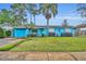 Charming one-story blue home with a lush green lawn, garage, and vibrant landscaping at 2565 Brookshire Ave, Winter Park, FL 32792