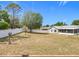 View of the backyard with a lovely blue home, white fence and sparse landscaping at 2617 Greywall Ave, Ocoee, FL 34761