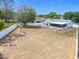 View of the backyard with a lovely blue home, white fence and sparse landscaping at 2617 Greywall Ave, Ocoee, FL 34761