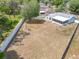 View of the backyard with a lovely blue home, white fence and sparse landscaping at 2617 Greywall Ave, Ocoee, FL 34761