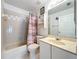 Bathroom with a shower-tub combination, single sink vanity, and patterned shower curtain at 2617 Greywall Ave, Ocoee, FL 34761