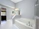 Bright bathroom features a large soaking tub, step-in shower with grey tiling, and neutral wall color at 2617 Greywall Ave, Ocoee, FL 34761