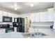 Well-lit kitchen featuring white cabinets, stainless steel appliances, and modern countertops at 2617 Greywall Ave, Ocoee, FL 34761