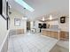 Spacious open-concept living space with tile flooring, skylight, and a view into the kitchen at 2617 Greywall Ave, Ocoee, FL 34761