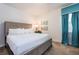Inviting bedroom featuring a plush king bed, accent wall art, and bright turquoise curtains at 291 Pendant Ct, Kissimmee, FL 34747
