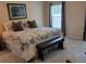Comfortable main bedroom featuring a queen-sized bed, a bench and ample natural light at 3020 Norlina St, Deltona, FL 32738