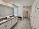 Bathroom with double sinks, granite countertops, and a glass-enclosed shower at 3024 Meleto Blvd, New Smyrna Beach, FL 32168