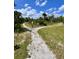 Crushed shell walking path lined with greenery on a sunny day at 3024 Meleto Blvd, New Smyrna Beach, FL 32168