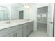 Bathroom featuring double sinks, gray cabinetry and view into the bedroom at 326 Wayland Dr, Haines City, FL 33844