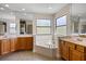 Bright bathroom with a tub, double mirrors, vanity and tile flooring at 3428 Deer Oak Cir, Oviedo, FL 32766