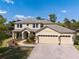 Beautiful two-story home with three-car garage, paver driveway, stone accents, and manicured landscaping at 3428 Deer Oak Cir, Oviedo, FL 32766