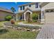 Charming two-story home featuring a paver walkway, stone accents, and lush landscaping at 3428 Deer Oak Cir, Oviedo, FL 32766