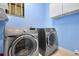 Efficient laundry room featuring a front load washer and dryer set with storage cabinets at 3428 Deer Oak Cir, Oviedo, FL 32766