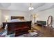 Spacious main bedroom with a dark wood bed frame, chest, seating and tray ceiling at 3428 Deer Oak Cir, Oviedo, FL 32766
