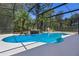 Inviting screened-in pool area with a waterfall feature, palm trees, and serene backyard views at 3428 Deer Oak Cir, Oviedo, FL 32766