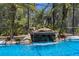 Close up of a stunning pool waterfall with lush landscaping and clear blue water at 3428 Deer Oak Cir, Oviedo, FL 32766