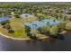 Aerial view of tennis and basketball courts on the lake framed by beautiful mature trees and landscaping at 3428 Deer Oak Cir, Oviedo, FL 32766