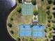 Aerial view of tennis and basketball courts located next to a lake surrounded by mature trees at 3428 Deer Oak Cir, Oviedo, FL 32766