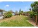 Large, grassy backyard with trees, shed, playset, fire pit, and privacy fence at 412 Stimson St, Orlando, FL 32839