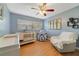 Bedroom with light blue walls, wood floors, crib, changing table, chair, and space themed tent at 412 Stimson St, Orlando, FL 32839